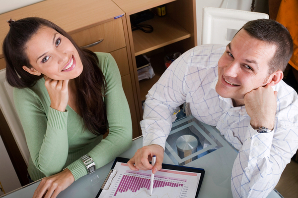 Dos personas sonriendo y mirando gráficos.